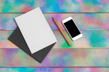 Akıllı telefon, tablet, tahta bir masanın arka planında kalem.