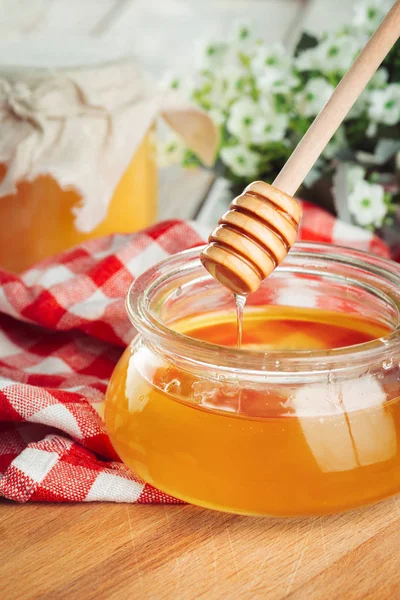 Honey background. Sweet honey in glass jar on wooden background.