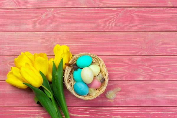 イースター 伝統とオブジェクトの概念 木の板の背景に色の卵とチューリップの花のクローズアップ — ストック写真