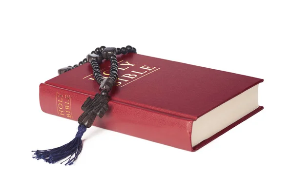 Bible on a white background. Sacred book and wooden rosary.