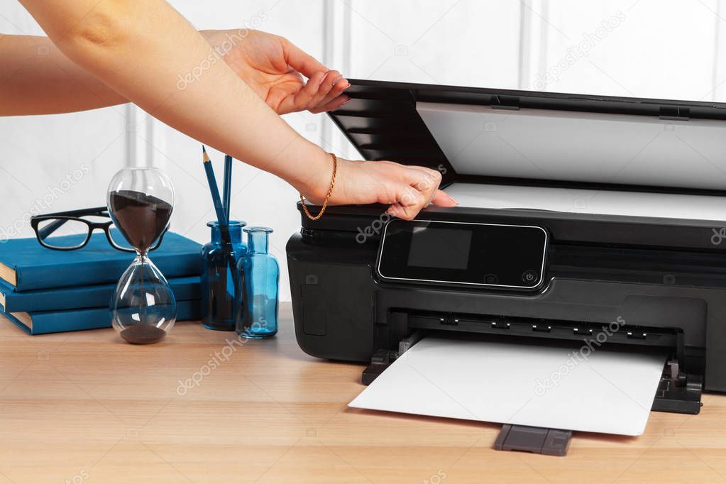 Female secretary making photocopies on xerox machine in office