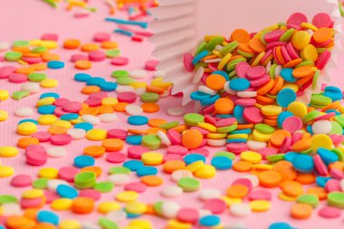 Şeker, yemek arkaplanını pembe karton üzerine serper.