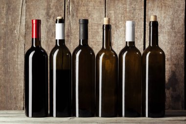 Ahşap arka planda bir şişe şarap.