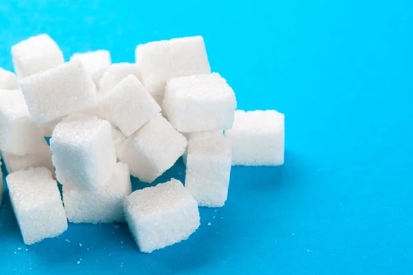 明るい青の背景に白い砂糖のキューブ — ストック写真