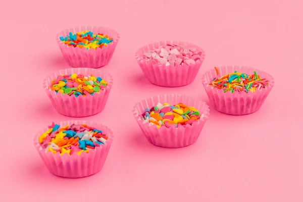 Sugar sprinkles  food background on pink cardboard