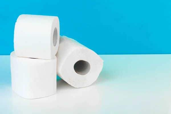 Три Рулона Туалетной Бумаги Изолированы Белом Столе Голубым Фоном — стоковое фото