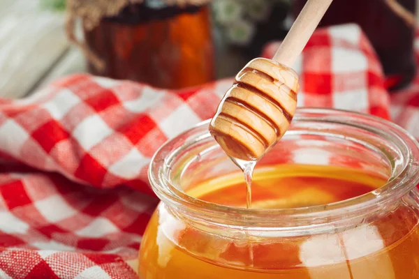 Bal geçmişi. Ahşap arka planda cam kavanozda tatlı bal.