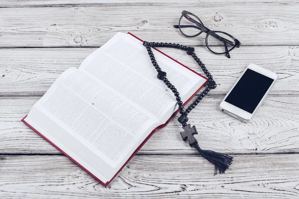 Kutsal İncil ve ahşap arka planda siyah kahve fincanı olan akıllı telefon..