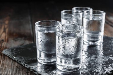Kırsal ahşap arka planda shot bardaklarında votka