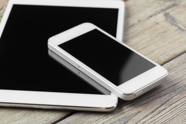 dijital tablet ve akıllı telefon masada.