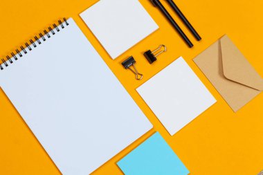 Model konsepti. Sarı arka planda kağıtlar. Üst görünüm, düz görünüm, kopyalama alanı