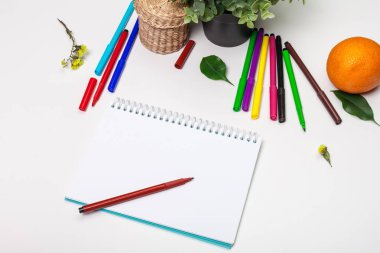 Farklı renklerde keçeli kalem seti ve metin için yeri olan boş bir çizim defteri