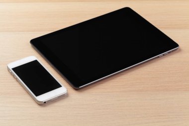 dijital tablet ve akıllı telefon masada.