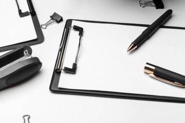 Beyaz arkaplan üzerinde beyaz sayfa ve kalem olan bir pano. Üst görünüm