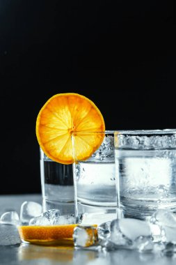 Siyah arka planda shot bardaklarında soğuk votka..