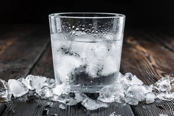 Vodka in shot glasses on rustic wood background