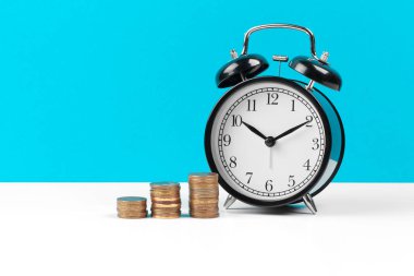 Masadaki çalar saat ve para paraları.