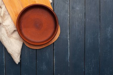 Boş tabak ve havlu ahşap masa arka planında.