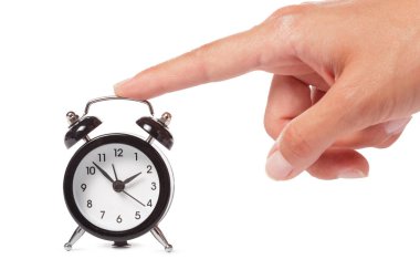 Beyaz arkaplanda alarmlı saati tutan kadın.