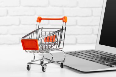 Alışveriş Çevrimiçi Konsept: Mini Alışveriş Arabası ve Laptop