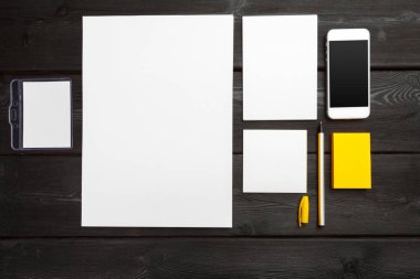 Kurumsal kimlik şablonu, siyah şık ahşap arka planda boş kırtasiye seti. Markalaşma, iş sunumları ve portföyler için modelleme yapın.