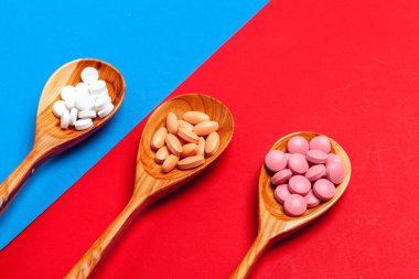 Bir renk arka plan yakından bir kaşık ta çok renkli haplar