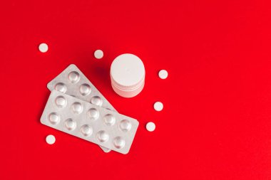 Kırmızı arka planda su toplayan haplar. İlaç.