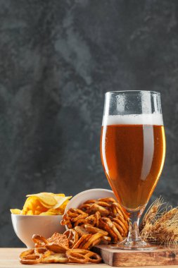 Bira bardağı ve kurutulmuş sosis aperatifleri yakın.