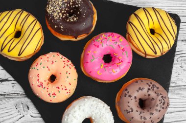 Tahta bir masada seramik tabakta birkaç taze çörek ve fotokopi alanı.