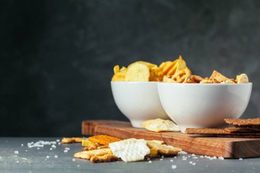 Taş masada bira atıştırmalıkları. Çeşitli krakerler, patates cipsi. Üst görünüm 