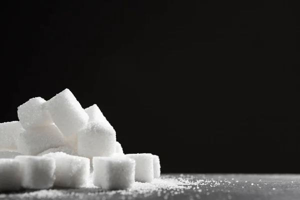 White sugar cubes over black background close up