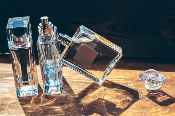 Több Üveg Parfümmel Napsugarakkal Asztalon — Stock Fotó
