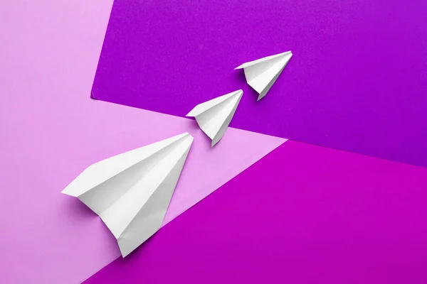 white paper airplane on a color block paper background