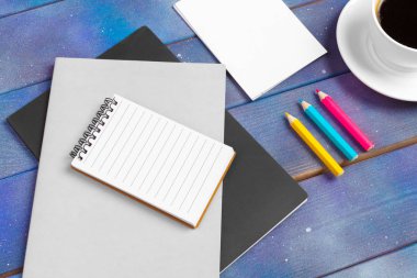 Kontrol listesi için model, mavi ahşap arka planda kahve fincanı olan boş not kağıdı. Ofis, yazar veya öğrenim kavramı