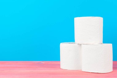 Parlak mavi arkaplanda tuvalet kağıdı yığını