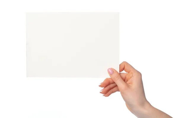 Womans hand holding blank white sheet of paper isolated on white — Stock Photo, Image