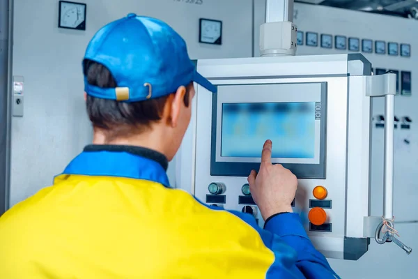 Man arbetare i tillverkningsanläggning vid kabel fabriken maskinstyrning datorpanel — Stockfoto