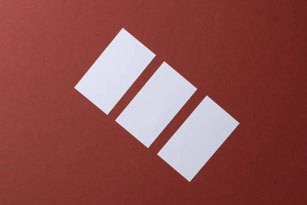 Cartões brancos em branco sobre fundo de papel borgonha — Fotografia de Stock