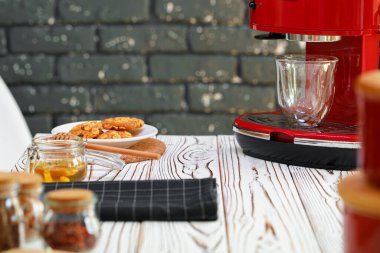 Mutfak tezgahında bardak olan kırmızı kahve makinesi.