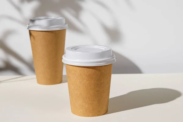 Kaffeetasse zum Mitnehmen mit Laubschatten, Kopierraum — Stockfoto