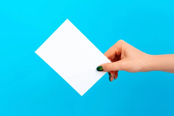 Woman hand holding blank card on blue background — Stock Photo, Image