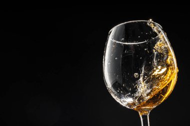 Siyah arka planda bir kadeh şarap, yakın plan.