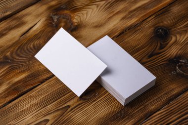 Kahverengi ahşap arka planda beyaz kartvizit yığını
