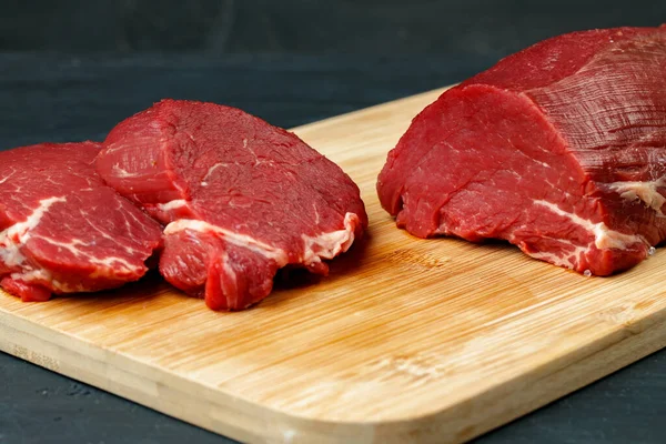 Fatia de filé de carne crua na placa de madeira — Fotografia de Stock