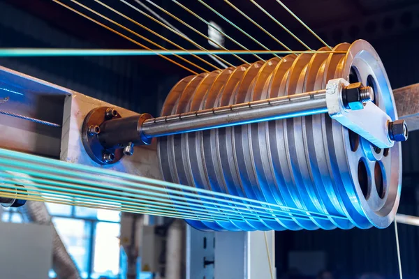 Elektrik kabloları ve optik fiberler üreten modern bir fabrikanın içinde. .Kablo üretim makinesi parçası.