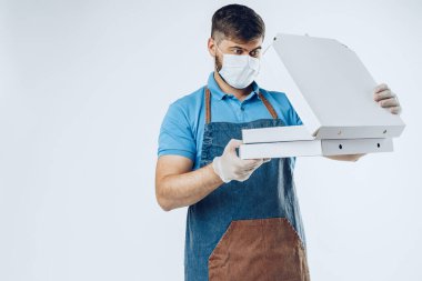 Tıbbi eldiven ve maske takan pizzacı. Coronavirüs covid-19 salgını sırasında güvenli servis