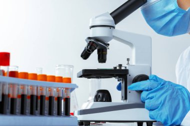 Mikroskopla çalışan kadın bilim adamının yakın plan fotoğrafı.