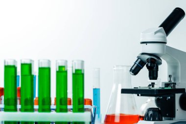 Renkli test tüpleriyle laboratuvar mikroskobu kapat