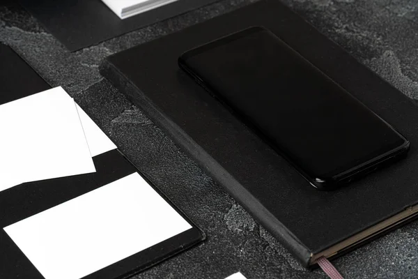 Mock up van blanco visitekaartje en zwarte smartphone scherm op tafel — Stockfoto