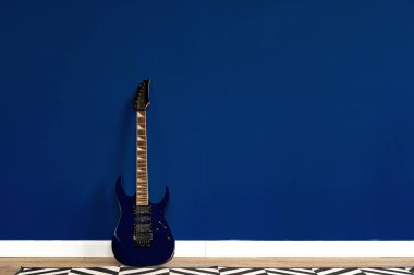 Dairede klasik mavi duvara karşı gitar kurulumu
